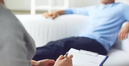 Danışanını dinlerken not alan psikolog